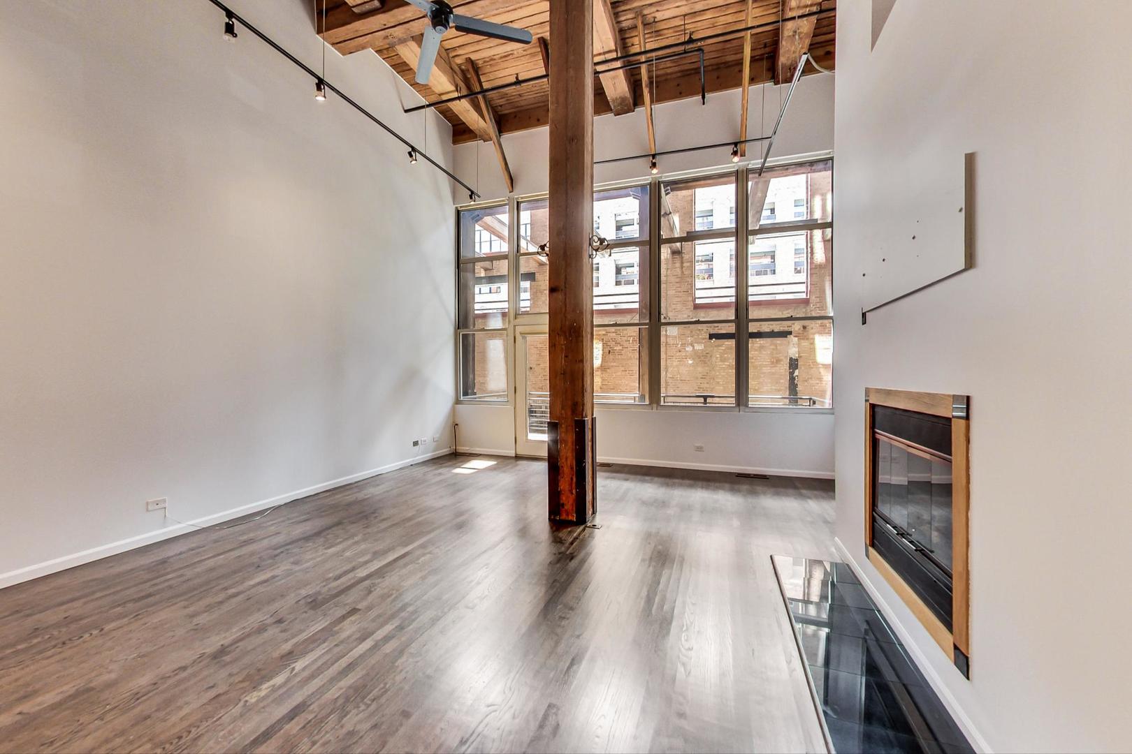 1000 West Washington Boulevard, Unit 130 Chicago, IL 60607 - Photo 12 of 47 a view of an empty room with wooden floor and a window