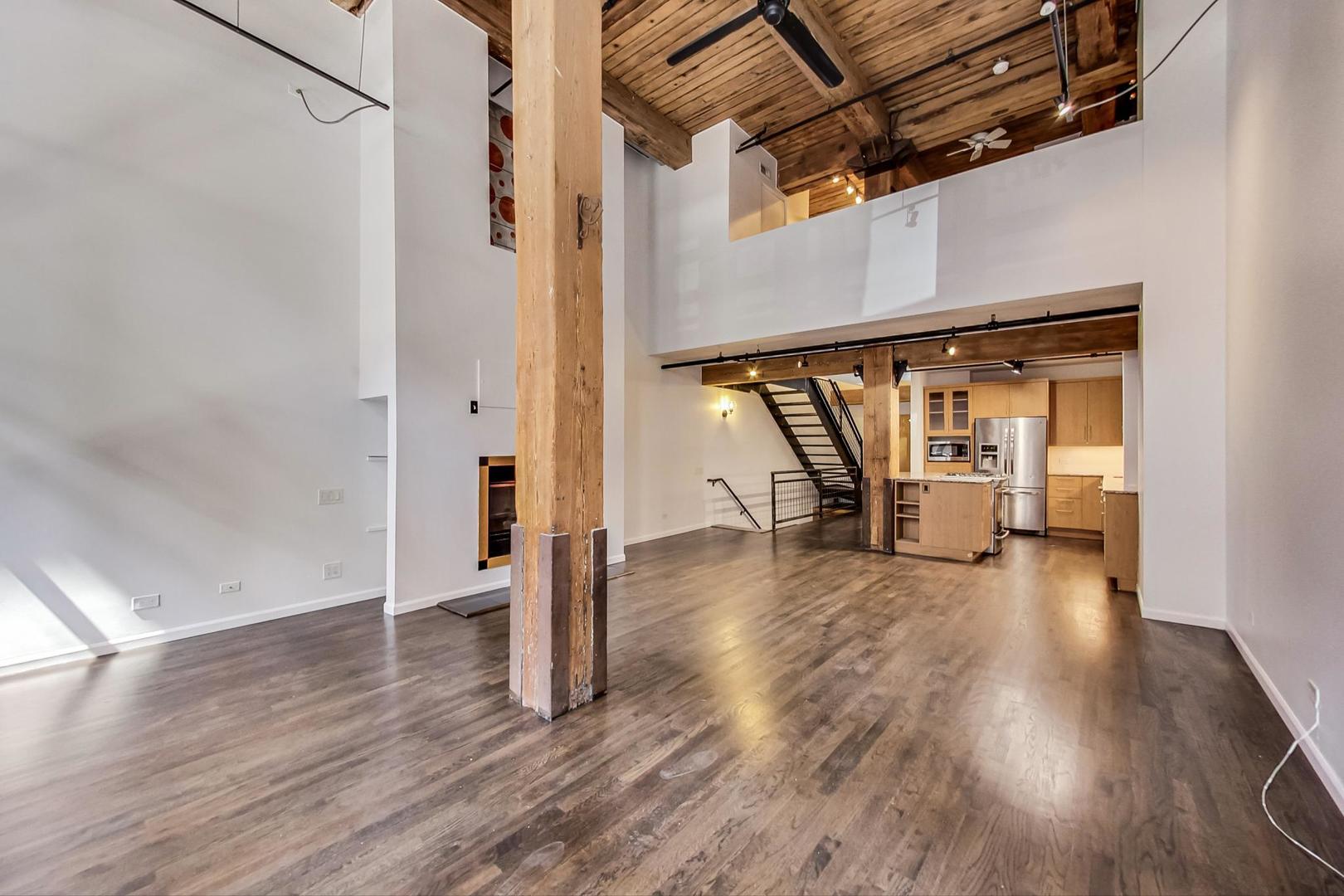 1000 West Washington Boulevard, Unit 130 Chicago, IL 60607 - Photo 13 of 47 a view of an empty room with wooden floor and stairs