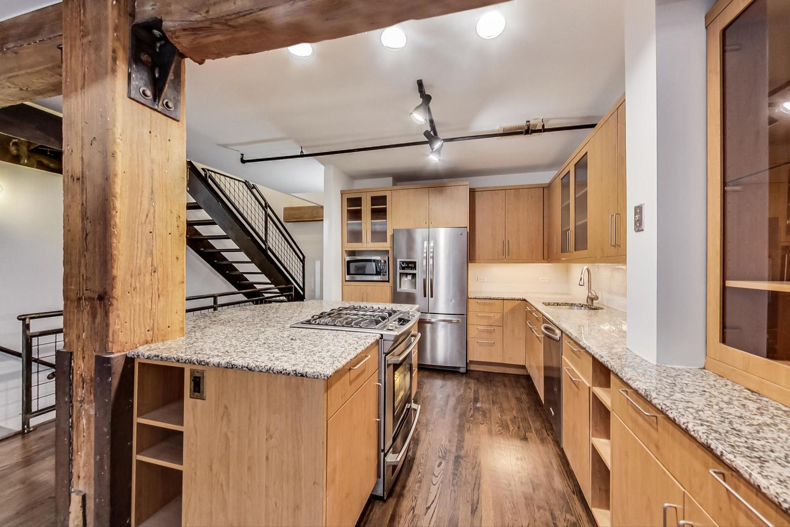 1000 West Washington Boulevard, Unit 130 Chicago, IL 60607 - Photo 18 of 47 a kitchen with stainless steel appliances granite countertop hardwood floor sink stove and refrigerator