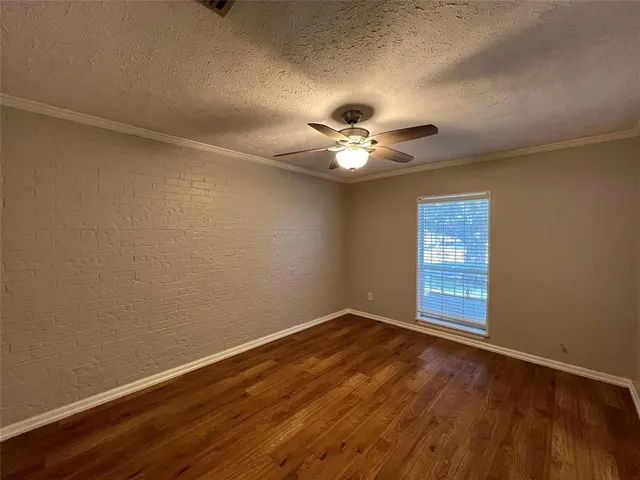 a view of an empty room with a chandelier fan