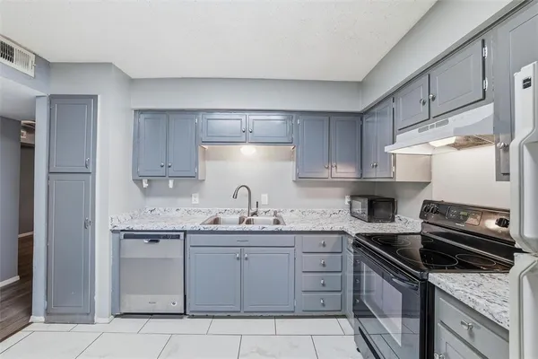 a kitchen with a sink stove and cabinets