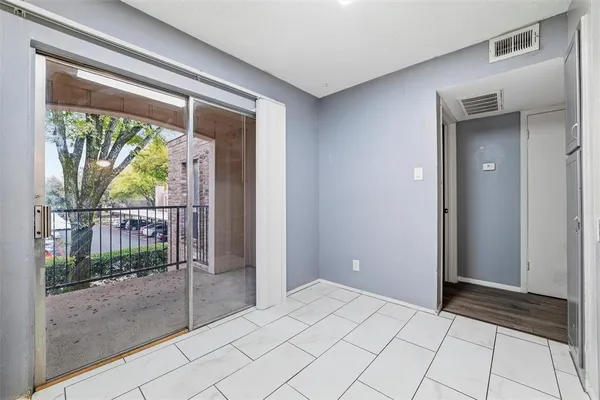 an empty room with a chandelier fan and wooden floor