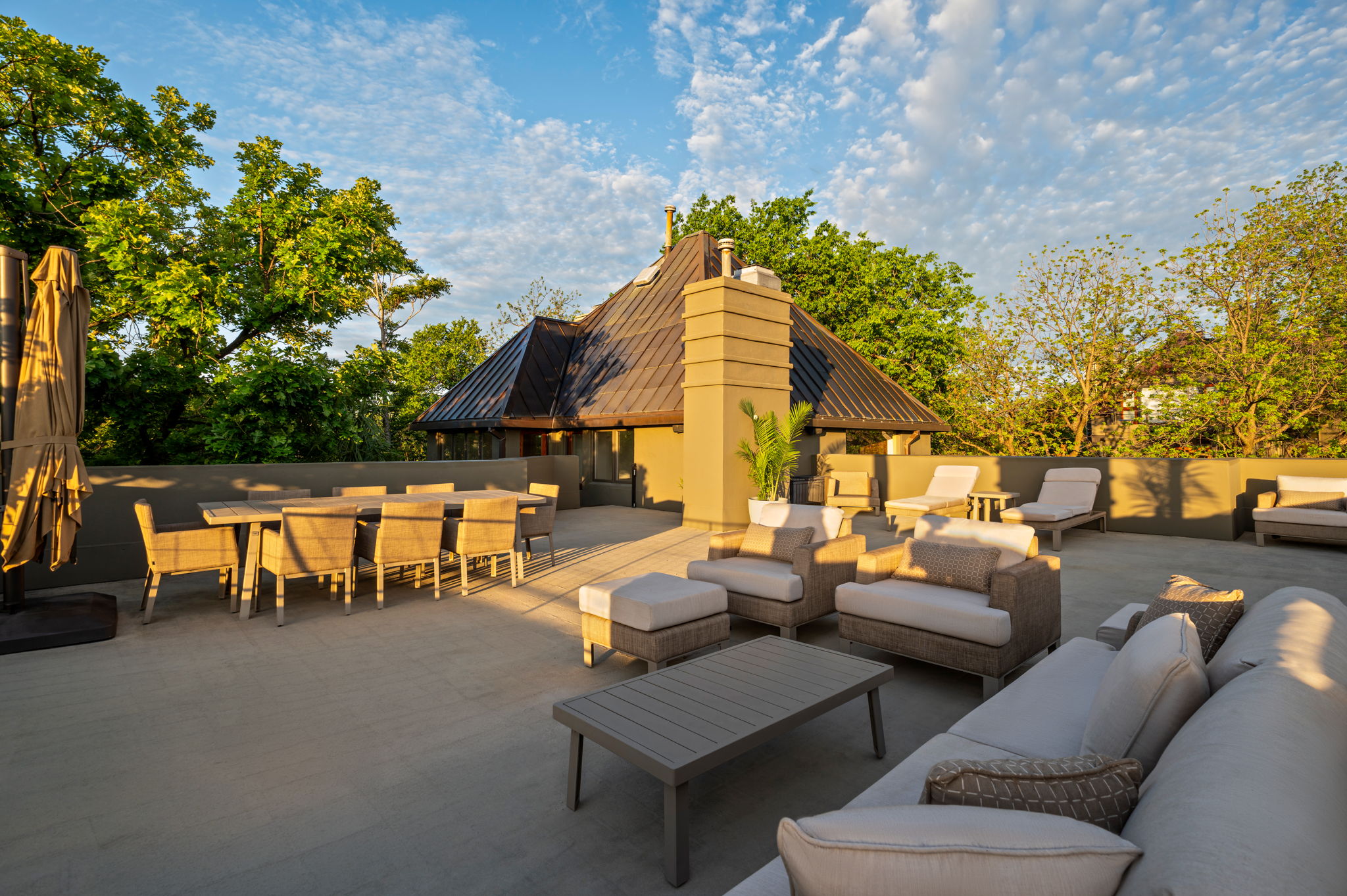 1111 West 12th Street, Unit 107 Austin, TX 78703 - Photo 11 of 38 Expansive rooftop terrace with a stucco chimney, surrounded by mature trees