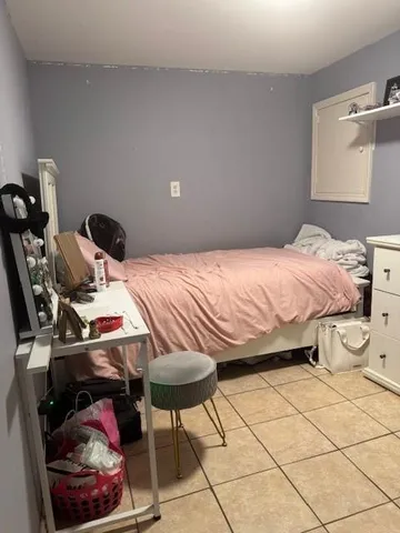 a bedroom with a bed and a lamp on dresser