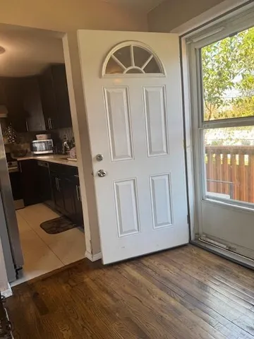 a view of a livingroom with wooden floor and a window
