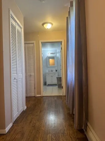 a view of a hallway with wooden floor