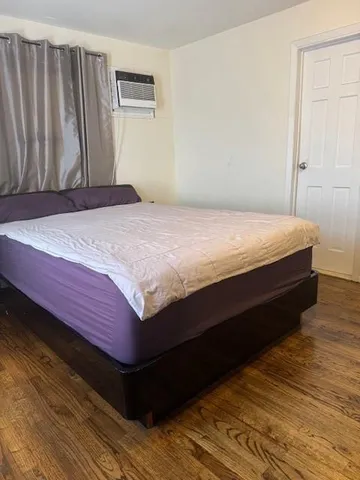 a bedroom with a bed and wooden floor