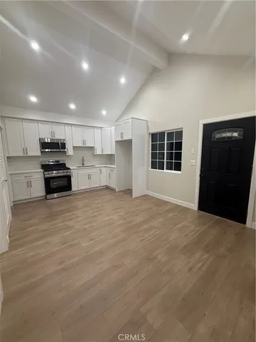 a kitchen with stainless steel appliances kitchen island granite countertop a refrigerator and a stove top oven