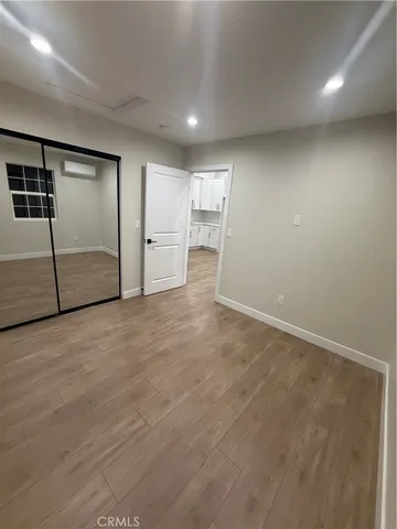 an empty room with wooden floor and glass door