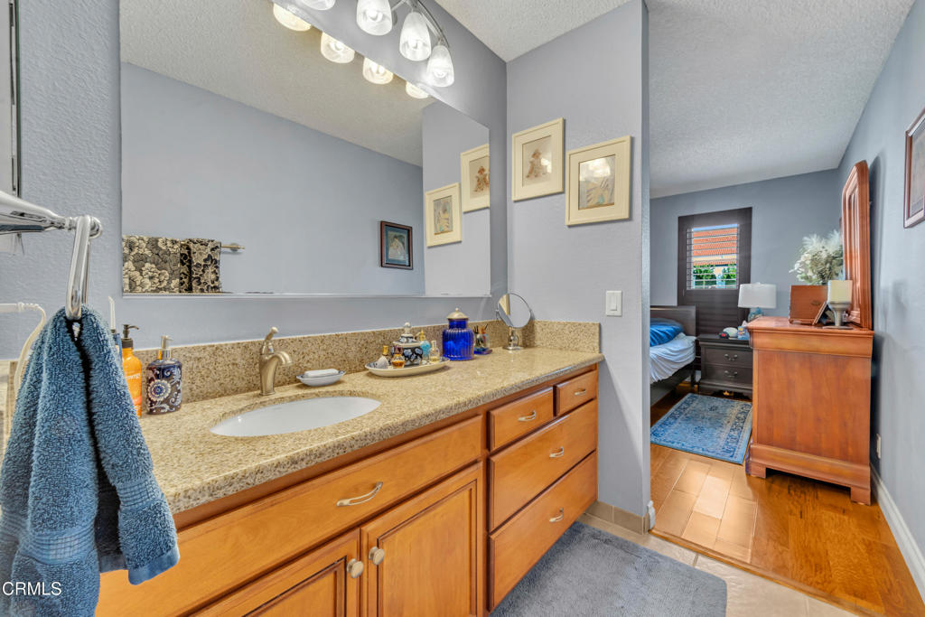 5290 Shiloh Way Ventura, CA 93003 - Photo 15 of 22 a en suite bathroom with a granite countertop sink and a mirror