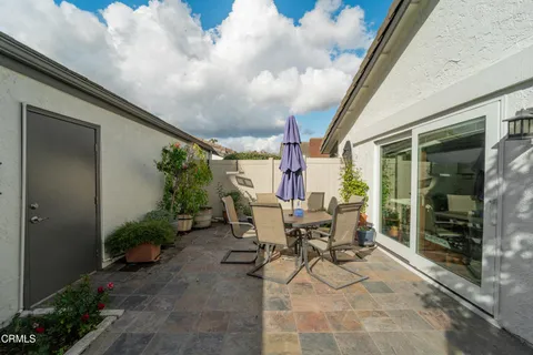 a view of a patio with table and chairs and potted plants