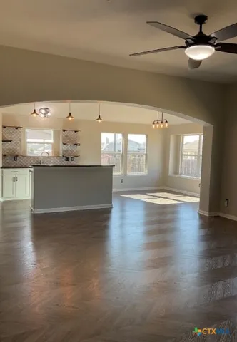 an empty room with wooden floor and large window