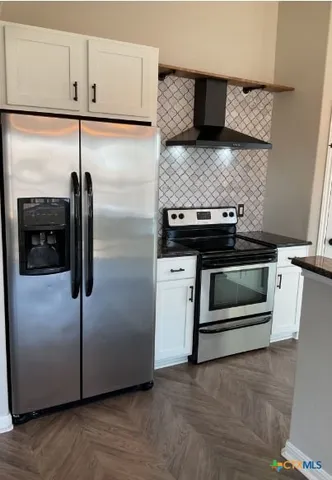 a kitchen with stainless steel appliances granite countertop a stove and a refrigerator