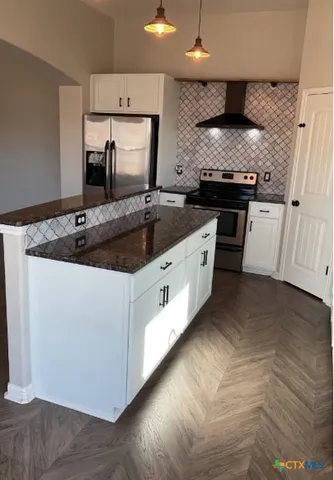 a kitchen with stainless steel appliances granite countertop a sink and a stove