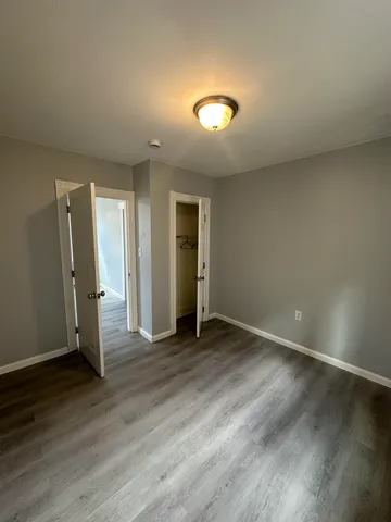 an empty room with wooden floor and entrance