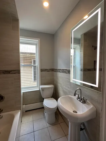 a bathroom with a sink mirror bathtub and toilet