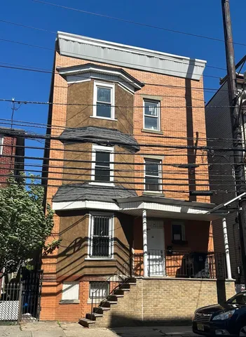 a view of a house with car parked on the road
