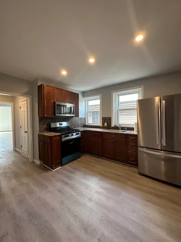 a kitchen with stainless steel appliances kitchen island granite countertop a refrigerator and a stove top oven