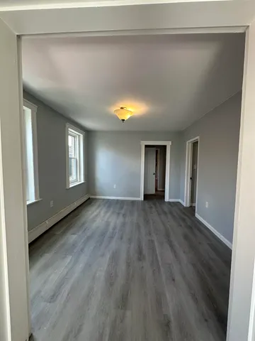 a view of empty room with window and wooden floor