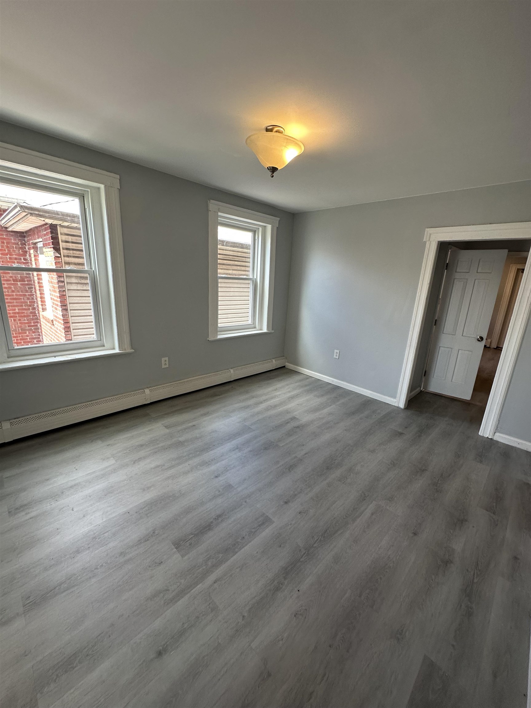 35 Norfolk Street, Unit 3 Newark, NJ 07103 - Photo 8 of 24 an empty room with wooden floor and windows