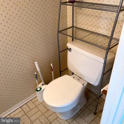 a white toilet sitting next to a shower