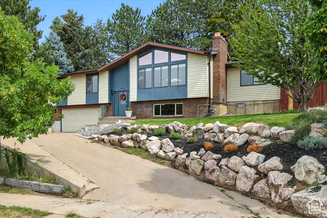 2923 South 400 East Bountiful, UT 84010 - Photo 1 of 1 Split foyer home with brick siding, a chimney, a garage, and concrete driveway