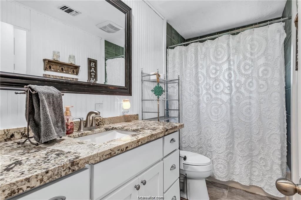 1510 Burt Street Bryan, TX 77802 - Photo 12 of 15 a bathroom with a granite countertop sink and a mirror