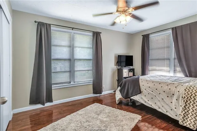 a bedroom with furniture wooden floor and a window