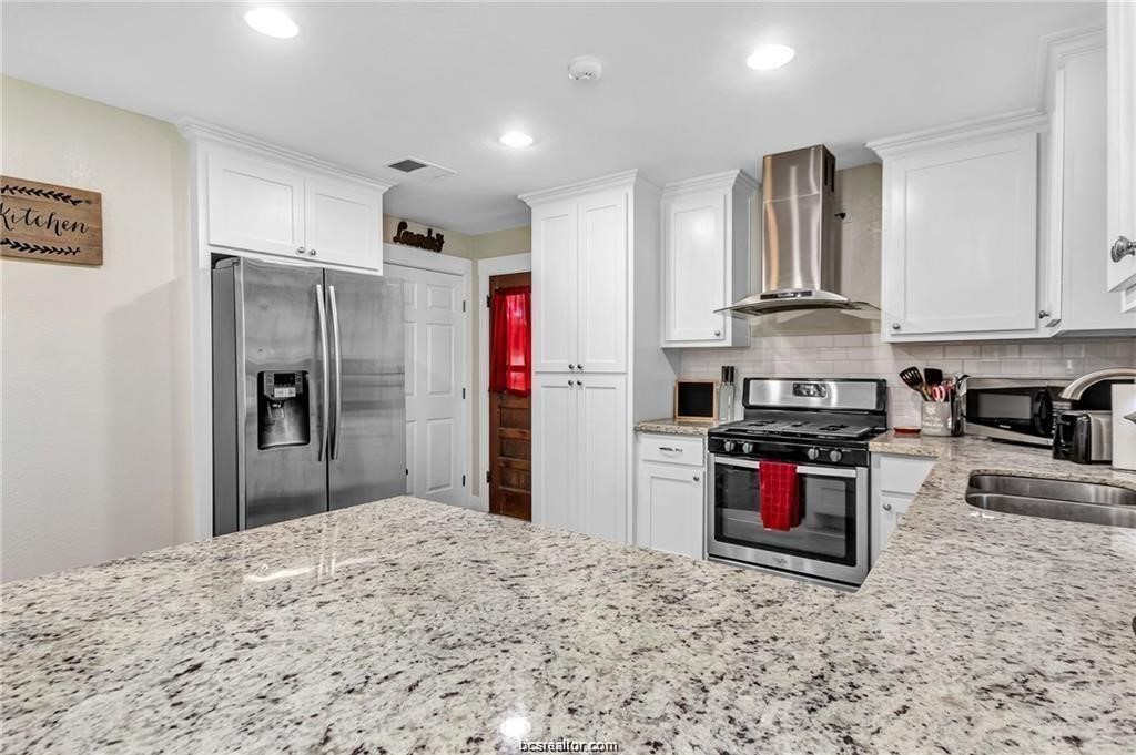 1510 Burt Street Bryan, TX 77802 - Photo 10 of 15 a kitchen with stainless steel appliances granite countertop a stove refrigerator and a sink