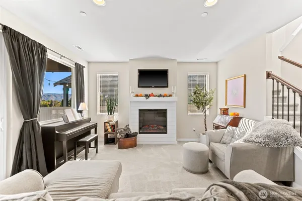 a living room with furniture a flat screen tv and a fireplace
