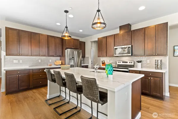 a kitchen with kitchen island granite countertop wooden cabinets a center island and appliances