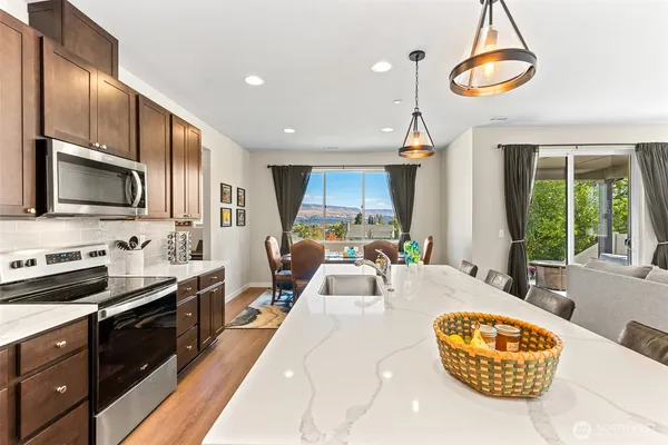 a large kitchen with kitchen island granite countertop a stove and a sink