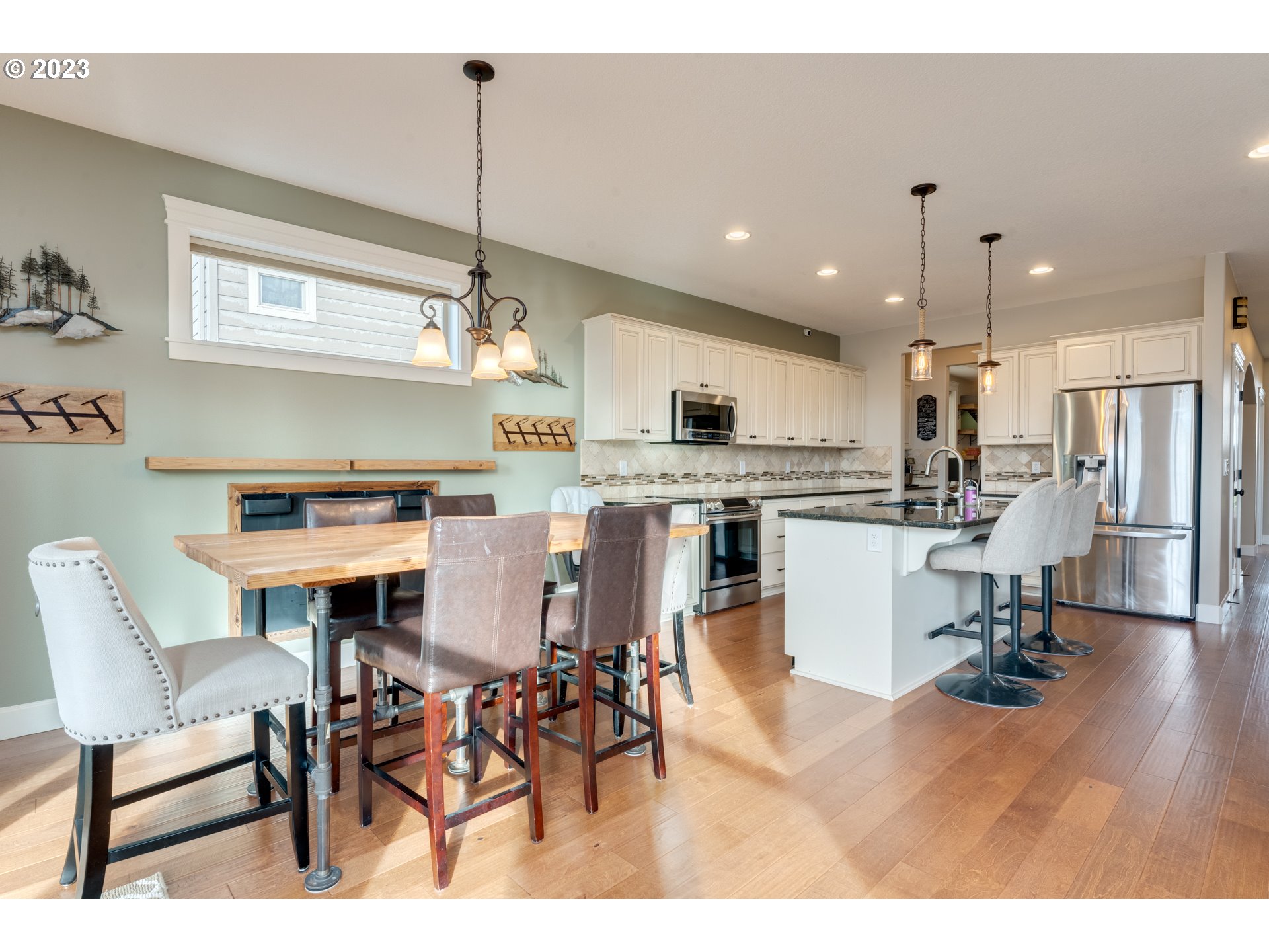117 North 38th Place Ridgefield, WA 98642 - Photo 9 of 32 a kitchen with stainless steel appliances kitchen island granite countertop a dining table chairs stove a refrigerator and a window