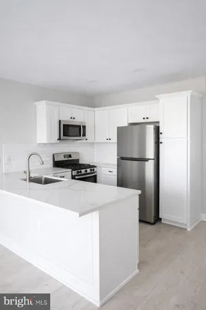 a kitchen with stainless steel appliances granite countertop a refrigerator a stove a sink a microwave and cabinets