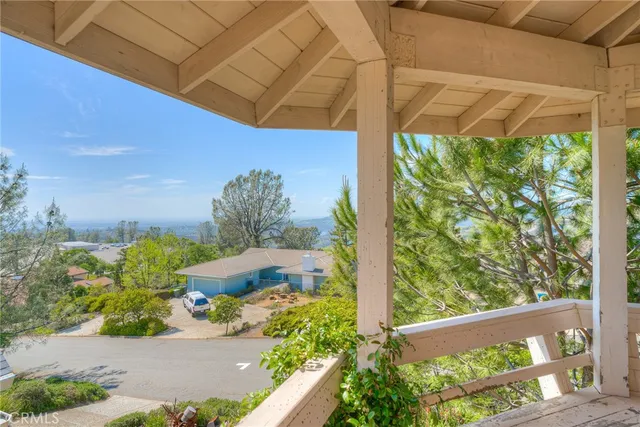 a view of an empty room with wooden floor fireplace and a window