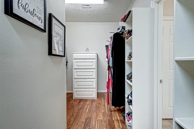 a view of walk in closet with clothes