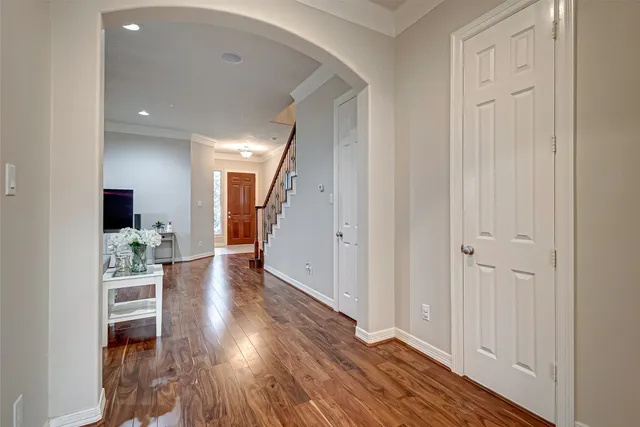 a view of a hallway with wooden floor table and staircase