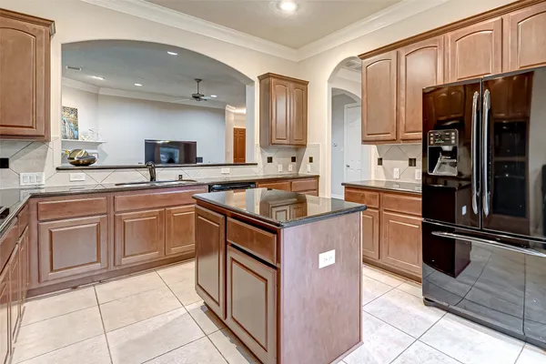a kitchen with kitchen island granite countertop a sink stove and refrigerator