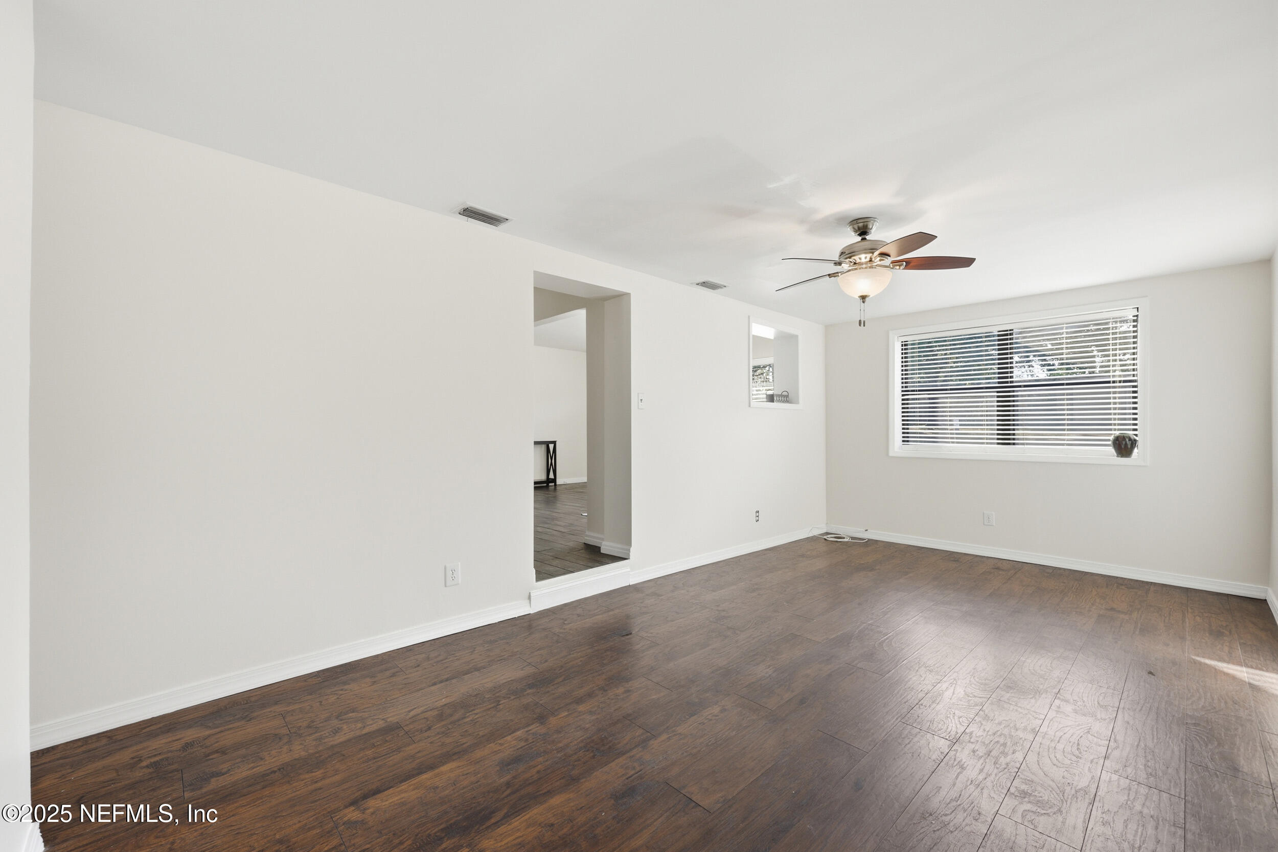 2947 Kline Road Jacksonville, FL 32246 - Photo 10 of 29 an empty room with wooden floor chandelier fan and windows
