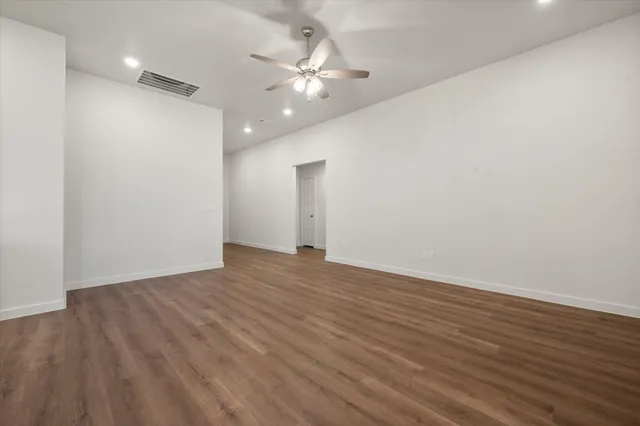 a view of an empty room with wooden floor