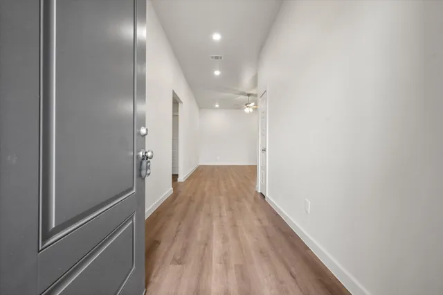 a view of a hallway with wooden floor