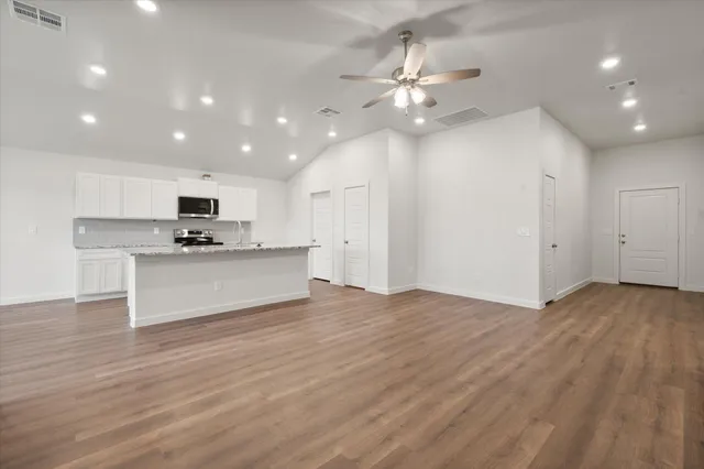 a view of kitchen with granite countertop cabinets and refrigerator
