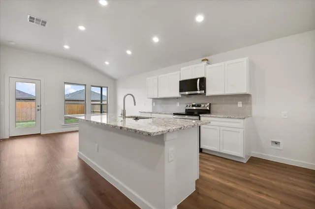 a kitchen with granite countertop a stove and a sink