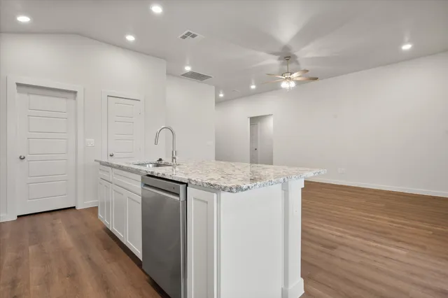 a kitchen with granite countertop a stove and a sink