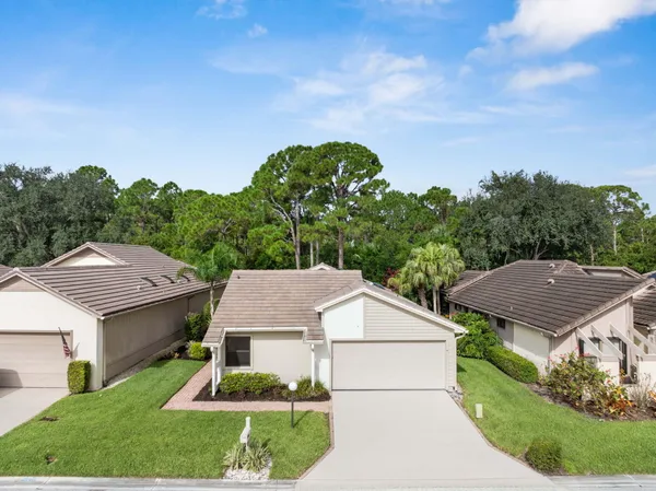 a aerial view of a house in a big yard with plants and large trees