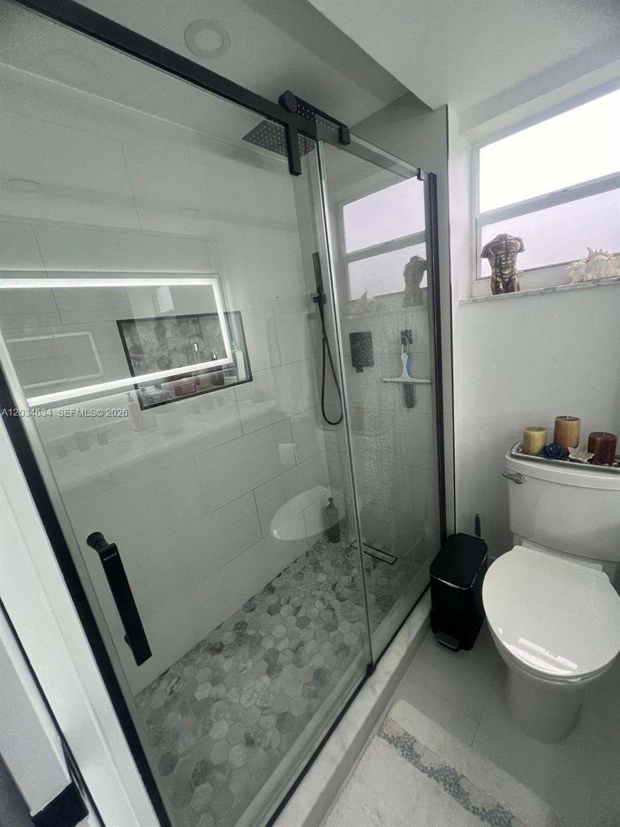 9880 Marina Boulevard, Unit 1516 Boca Raton, FL 33428 - Photo 16 of 32 a bathroom with a toilet and a shower