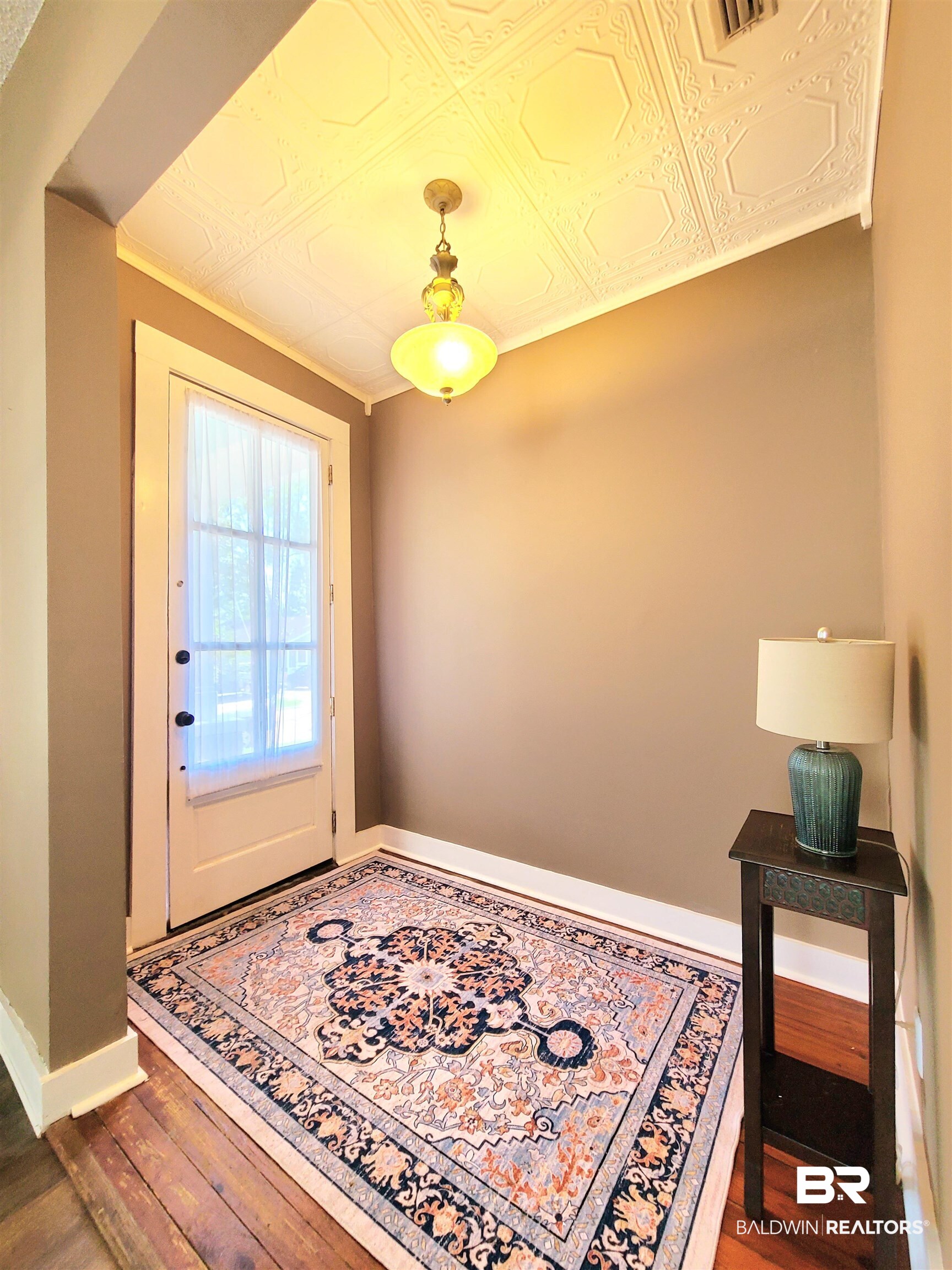 112 Espejo Street Mobile, AL 36604 - Photo 18 of 20 Doorway to outside with an ornate ceiling, wood finished floors, visible vents, and baseboards