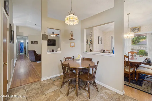 a view of a dining room with furniture and a chandelier