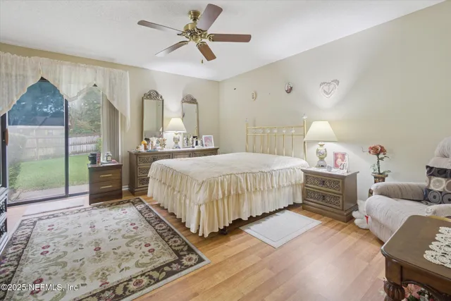 a bedroom with a bed a dresser and wooden floor