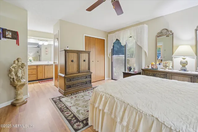 a spacious bedroom with a bed a dresser and wooden floor